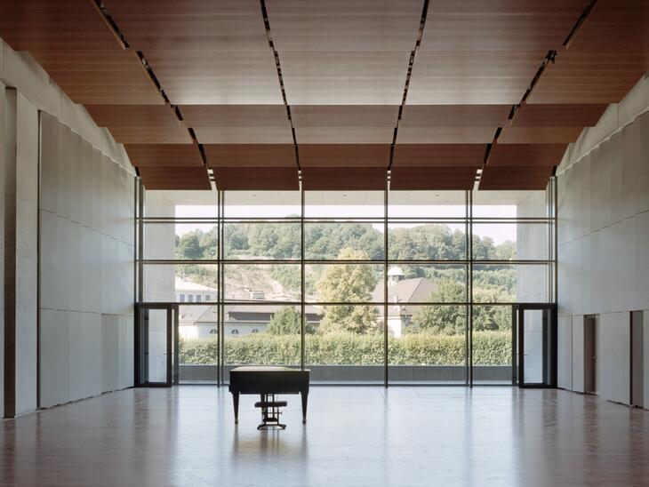 © Andrew Phelps Leerer Solitär, Parkettboden, große Fensterfront, davor ein Piano | © Andrew Phelps
