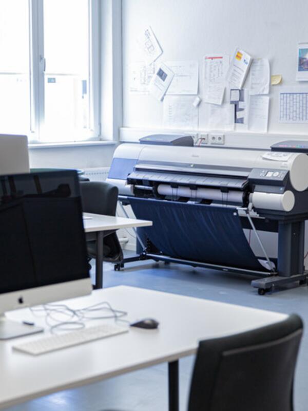 Medienraum, großer Drucker, Arbeitstische mit Computern