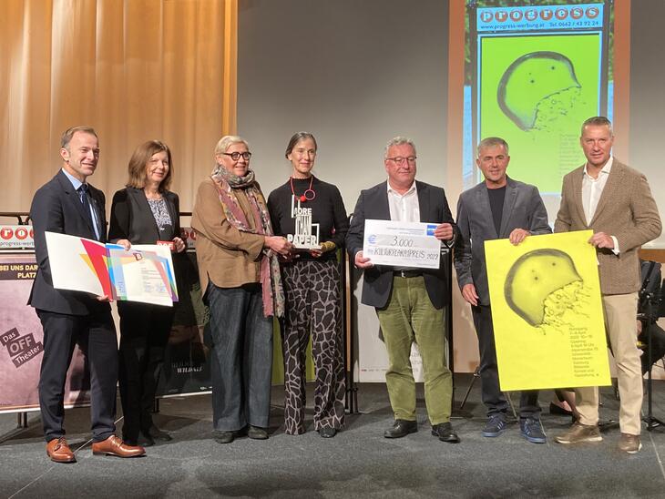 Gruppenfoto, Menschen mit einem neongelben Plakat mit einer Qualle und Auszeichnungen in den Händen