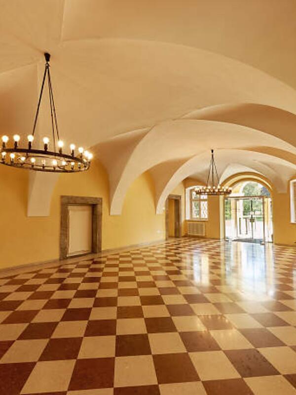 Schloss Frohnburg Foyer | © Christian Schneider Eingangshalle der Frohnburg, Fliesen im Schachbrettmuster, runde Decke, minimalistischen Kronleuchter | © Christian Schneider