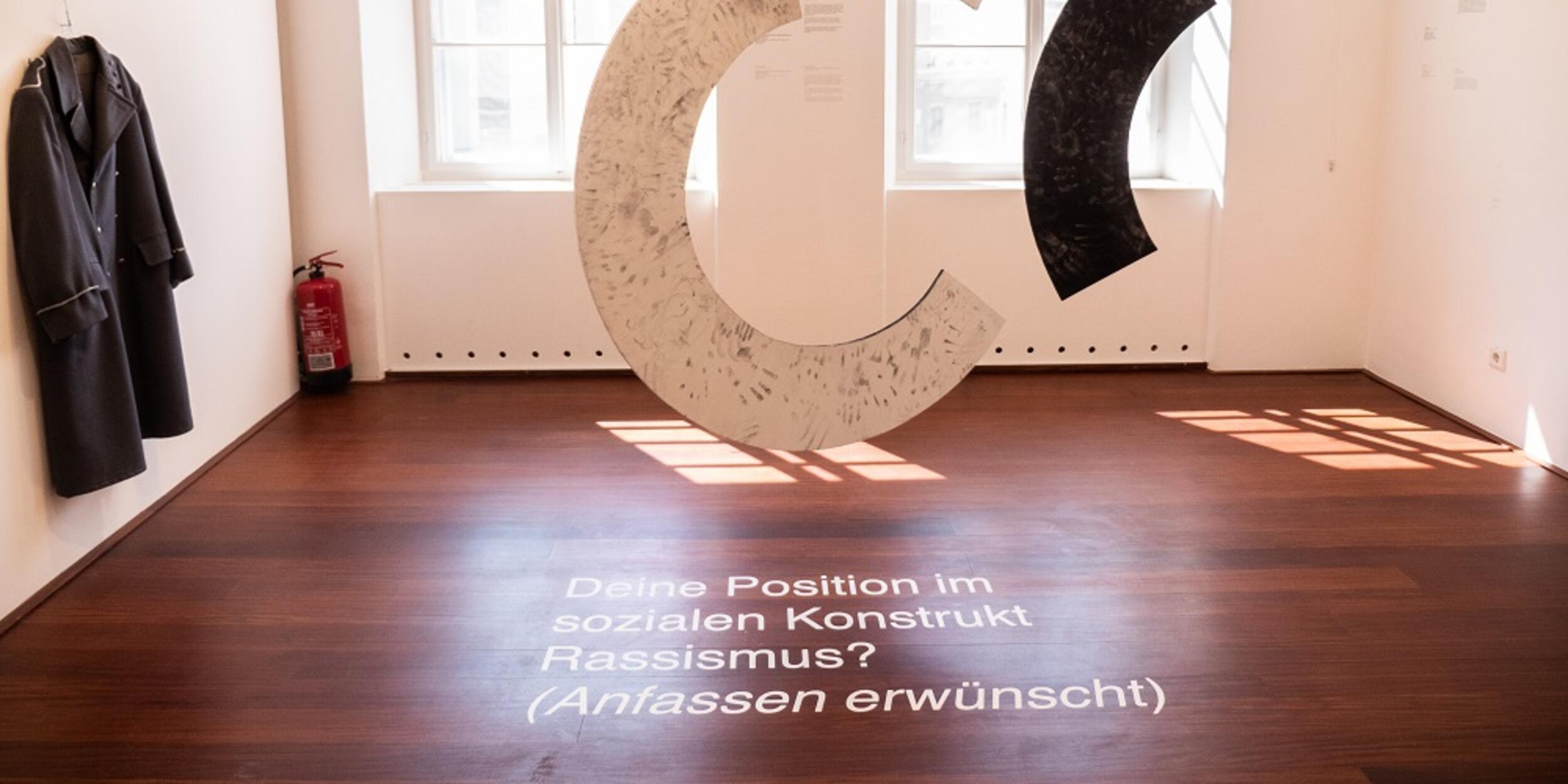 Bild der Ausstellung, ein C schwebt inmitten des Raumes | © Fabian Schober