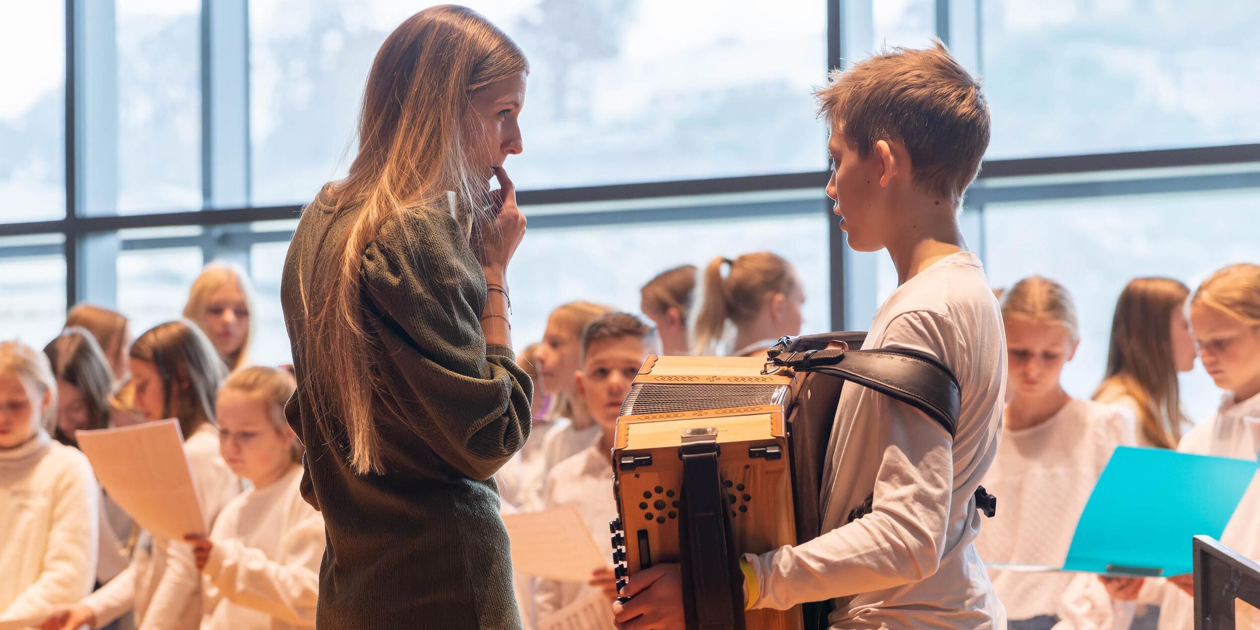 Weihnachtslieder Sing Along Konzert | © Christian Schneider Kinderchor mit Lehrerin und Jungen mit Akkordeon | © Christian Schneider