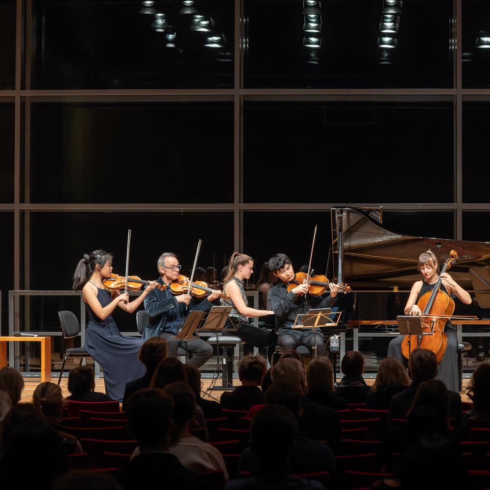 Musiker*innen auf einer Bühne, Streichquartett, Piano, Klarinette und Kontrabass | © Christian Schneider