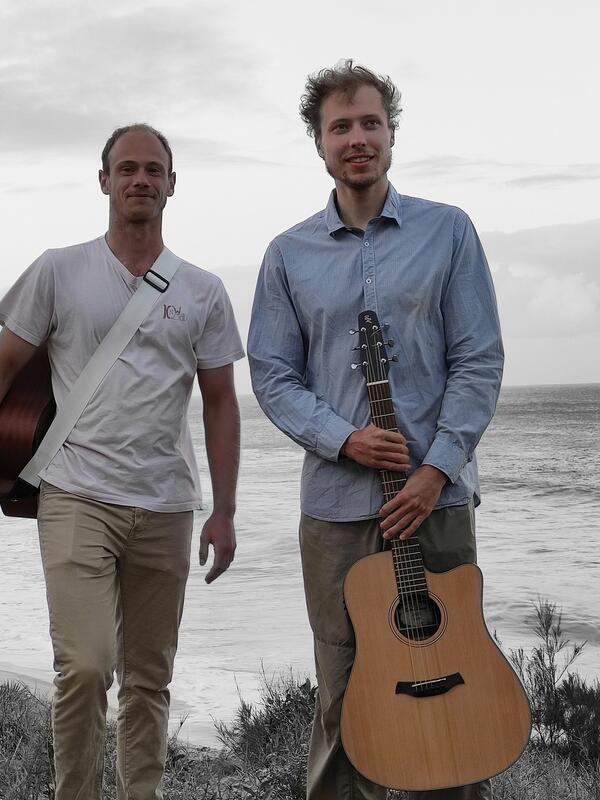 Zwei Männer mit Gitarren an einem Strand, Blick in die Kamera | © Felix Buschbeck