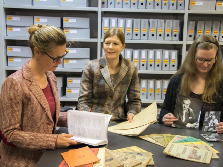 Team des Kunst-Archiv-Raum an einem Tisch mit alten Fotografien und Dokumenten | © Universität Mozarteum