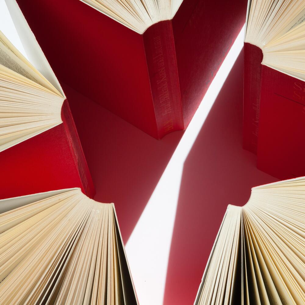 Rote Bücher sind mit dem Rücken zueinander sternförmig angeordnet | © Pixabay