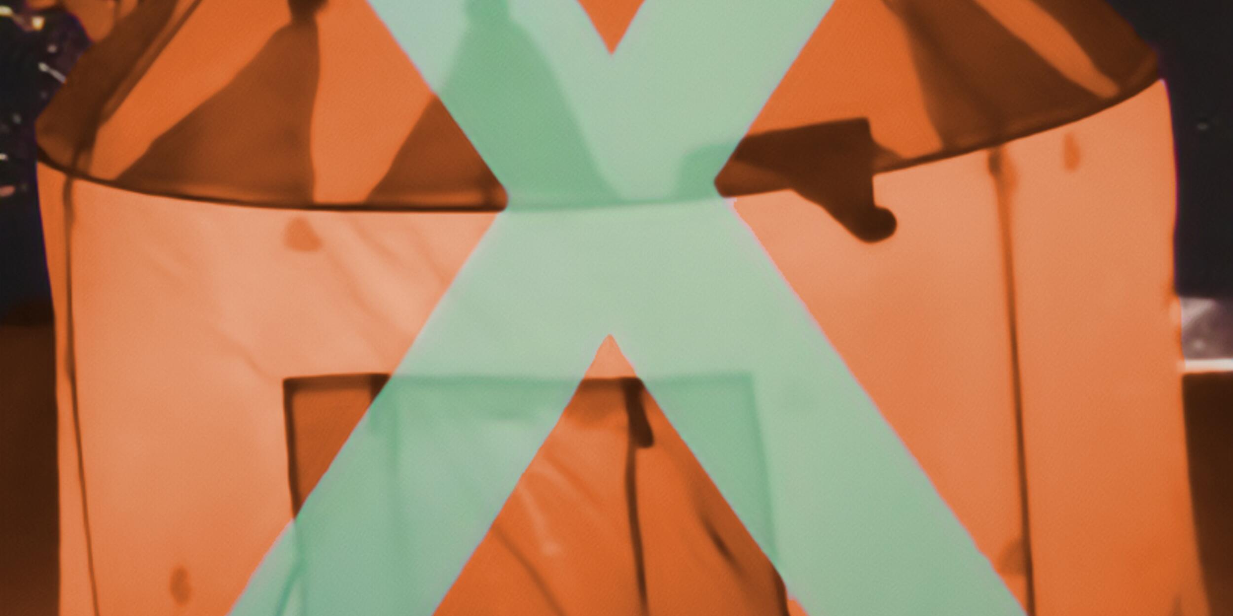 Ein oranges Zelt, darüber ein türkises X | © Applied Theatre