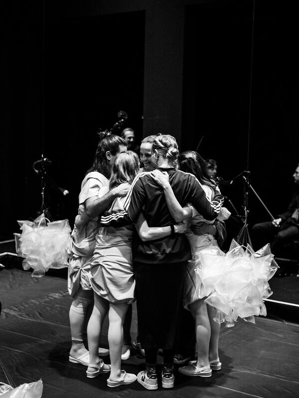 Bild schwarz-weiß, fünf Menschen stehen nah beieinander im Kreis | © Fabian Schober