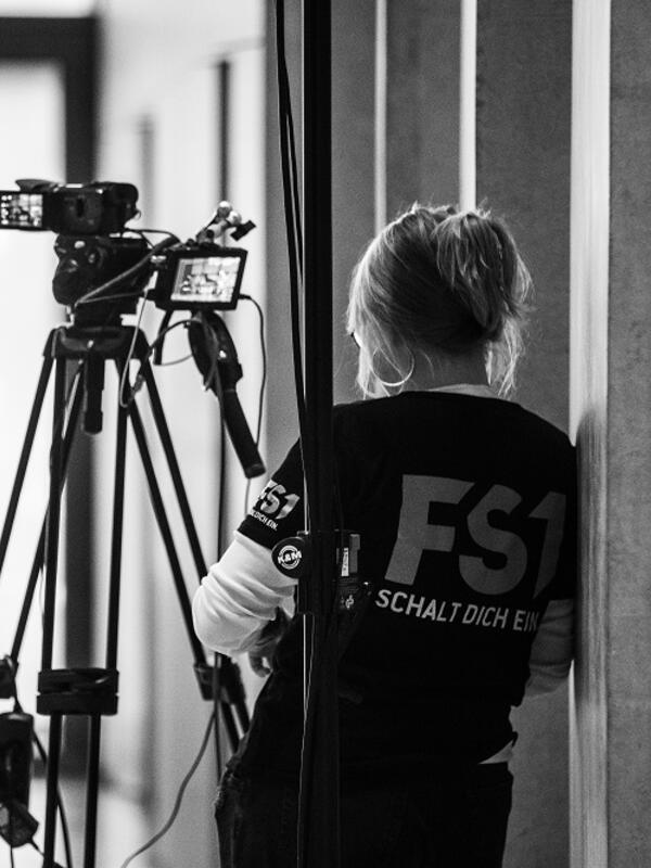 Bild schwarz-weiß, Kamerafrau von FS1 von hinten an ihrer Kamera | © Fabian Schober