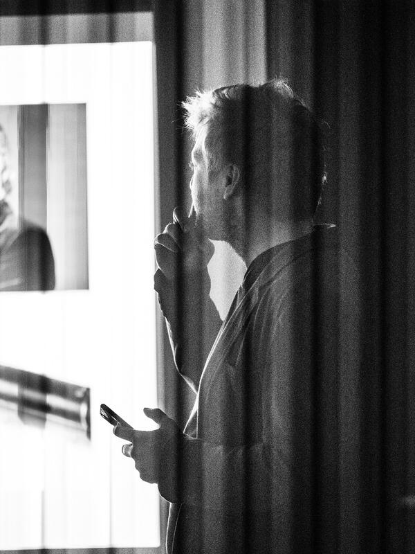 Bild schwarz-weiß, Mann von schräg hinten, er sieht auf eine Beamerprojektion | © Fabian Schober