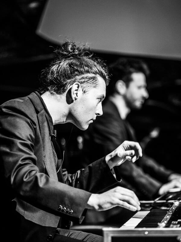 Bild schwarz-weiß, Mann sitzt am Stagepiano, sieht konzertiert nach vorne | © Fabian Schober