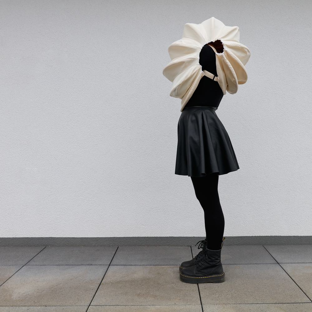 Eine Frau verbirgt ihren Kopf in einer Muschel aus Papier | © Sebastian Albert